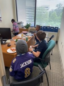 Children sitting at a desk with pizza