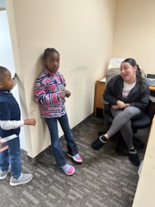 Adult woman sitting in a chair talking to children