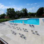 Wide shot of a community pool area with longe chairs